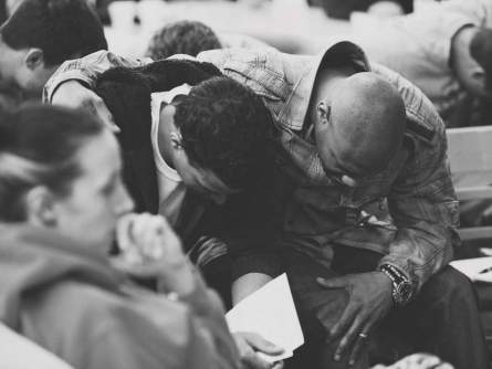 Pastor Eugene Taylor praying with another church goer